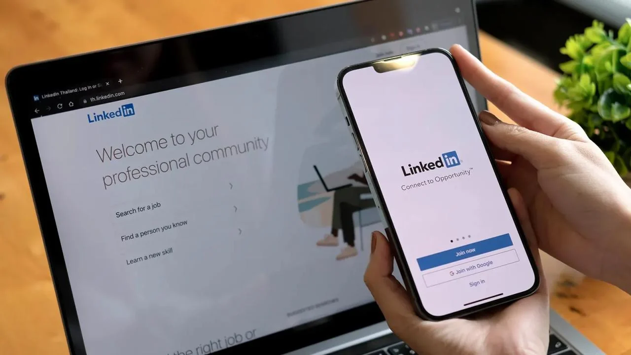 Mobile phone and laptop used for LinkedIn networking and professional communication